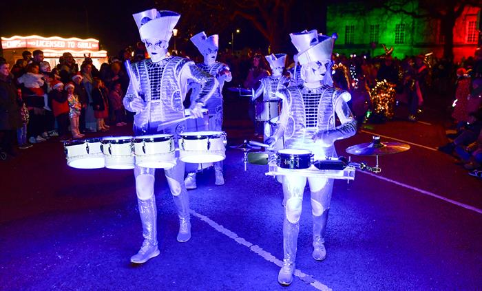 Illuminated drummers in festive costume taking part in the Swansea Christmas Parade